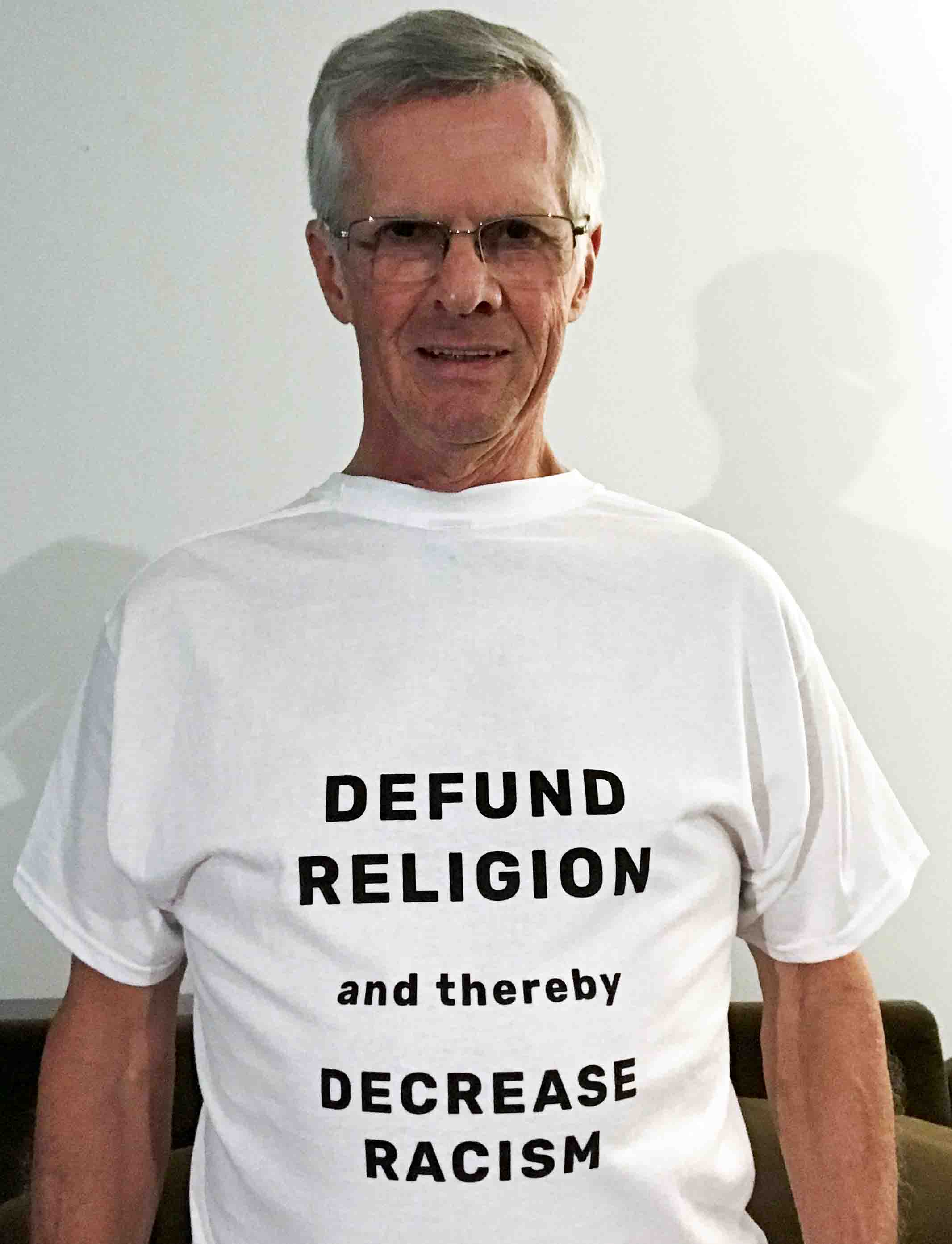 Darwin wearing a T-shirt that says Defund Religion and thereby decrease racism