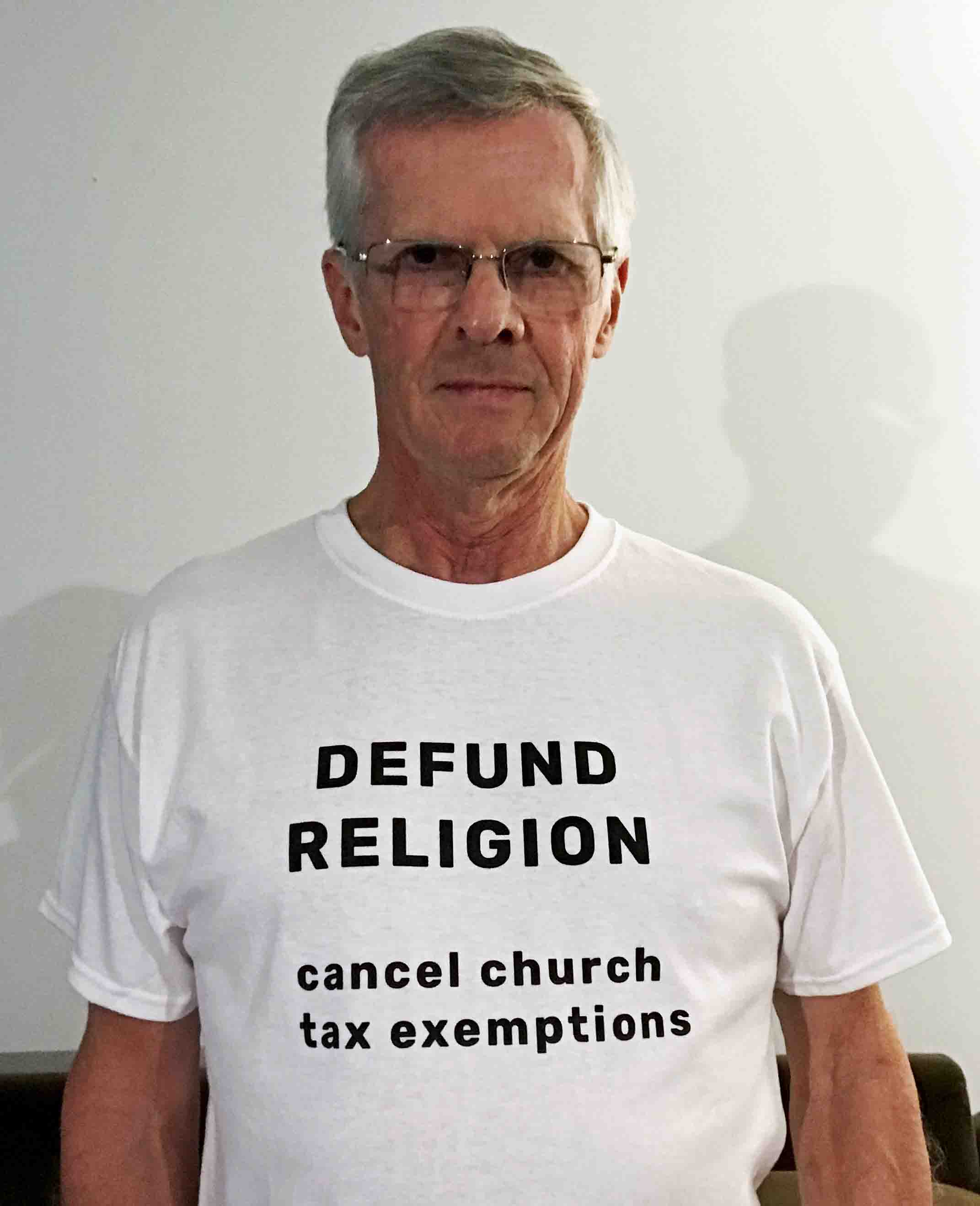 wearing a T-shirt that says Defund Religion, cancel church tax exemptions